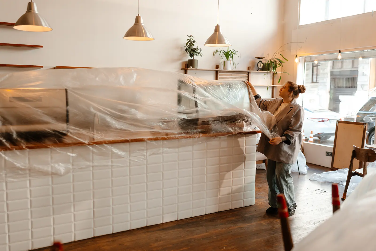 Commercial renovation in progress with protective plastic covering fixtures during interior construction work
